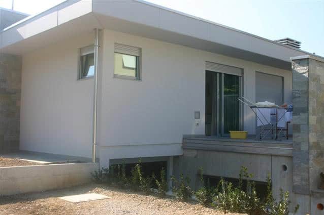 Casa moderna con terrazza e grandi finestre, costruzione Dallapè Srl.