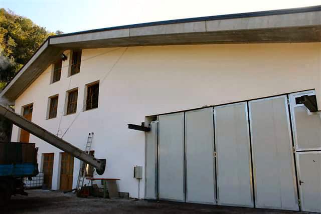 Costruzioni Dallapè Srl, edificio industriale con grandi porte metalliche.