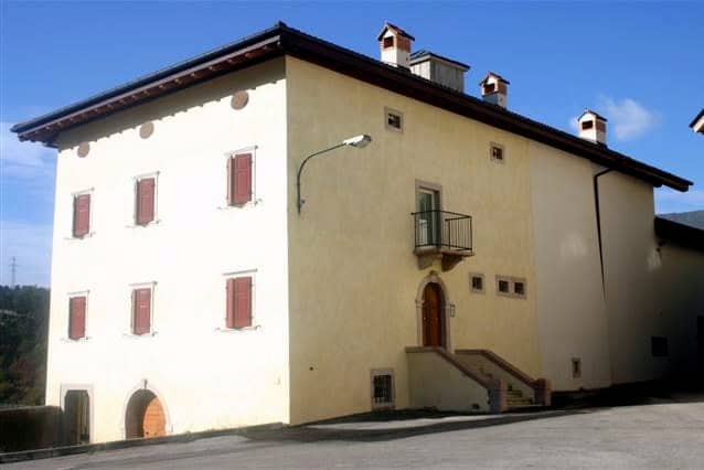 Edificio residenziale in stile tradizionale con balcone e finestre in legno.