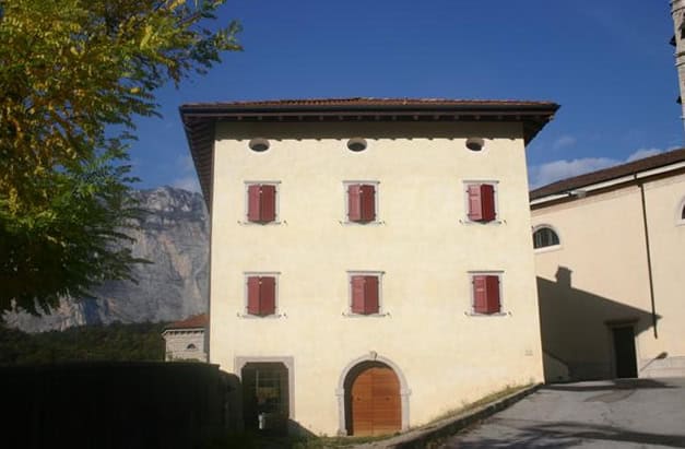 Costruzioni Dallapè Srl edificio storico a Canonica Lasino con mura bianche e finestre rosse.