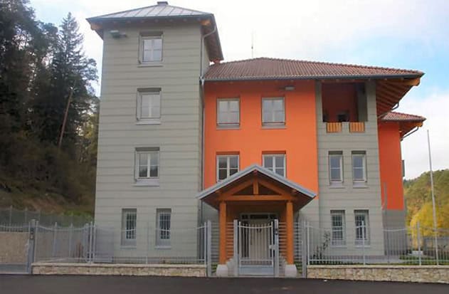 Edificio residenziale con facciata colorata e ingresso principale in legno.