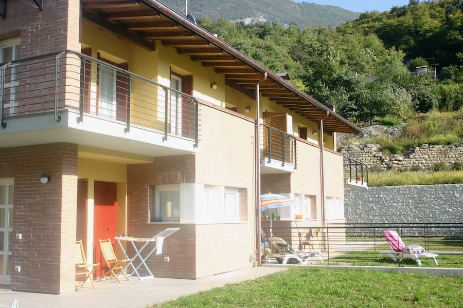 Moderna costruzione residenziale con balconi e giardino.