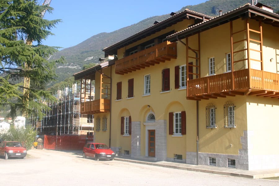 Edificio residenziale in stile tradizionale con balconi in legno e facciata gialla.
