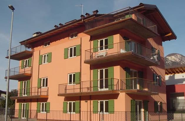 Residenza Vela edificio residenziale con balconi e finestre verdi.