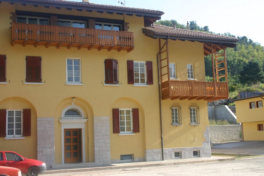 Edificio residenziale in stile tradizionale con balconi in legno e facciata gialla.