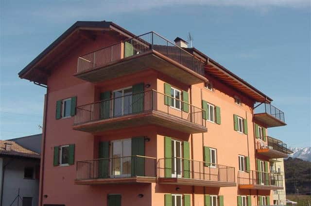 Residenza Vela edificio residenziale con balconi e finestre verdi.