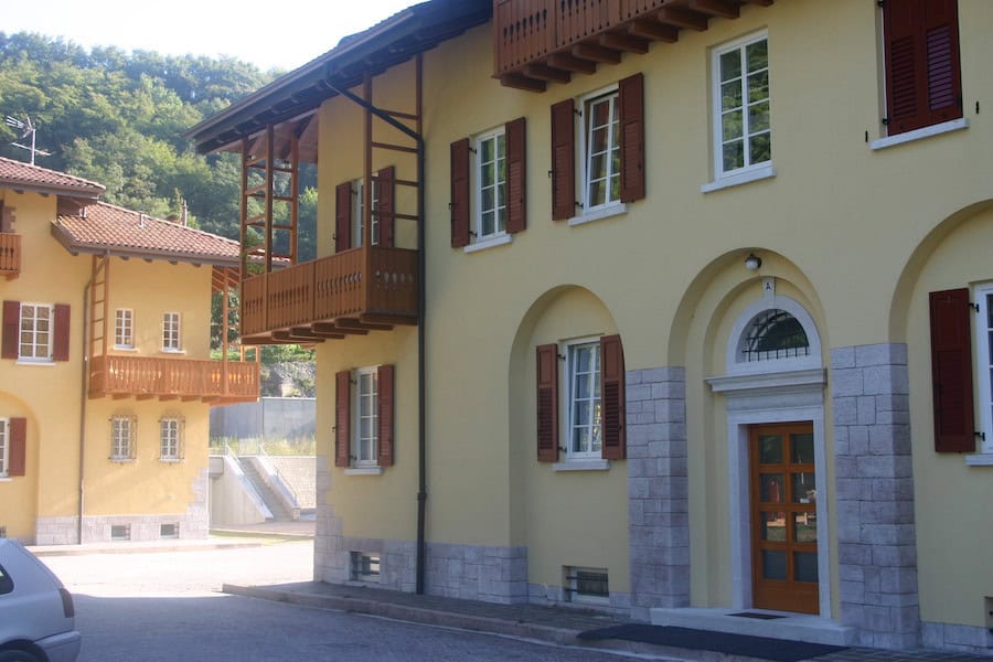Edificio residenziale in stile classico con facciata gialla e dettagli in pietra.