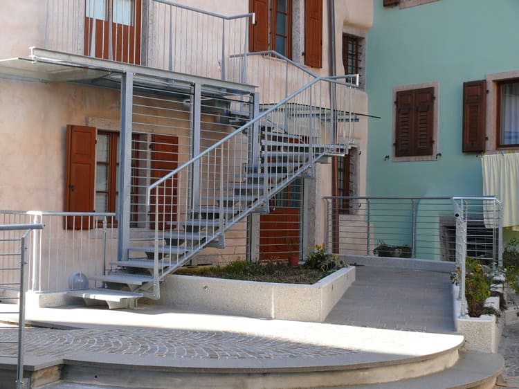 Scala esterna in metallo con ringhiera in ferro, accesso a piano superiore.
