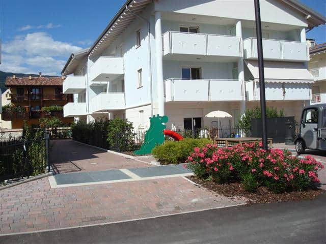 Residenza EOS edificio residenziale con balconi e giardino ben curato.