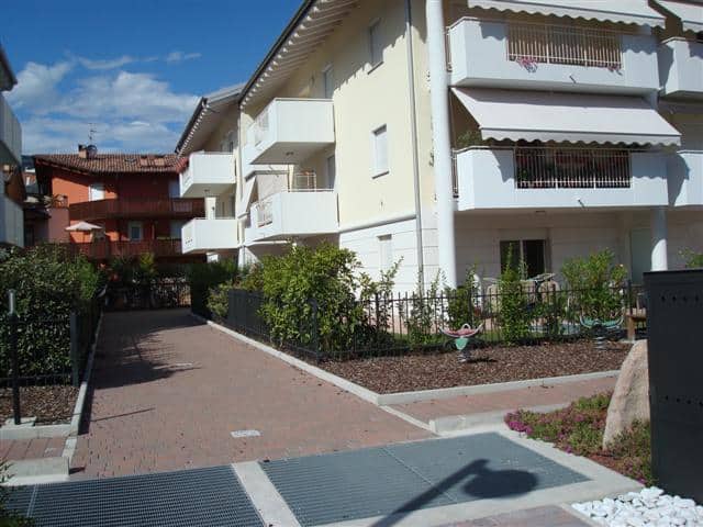 Edificio residenziale moderno con balconi e giardino ben curato.