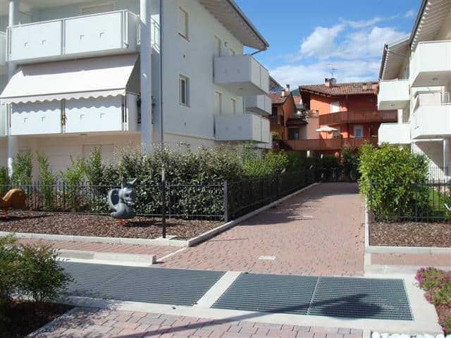 Edificio residenziale moderno con giardini e accesso pedonale.