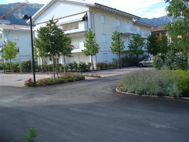 Edificio residenziale moderno con giardino e parcheggio.