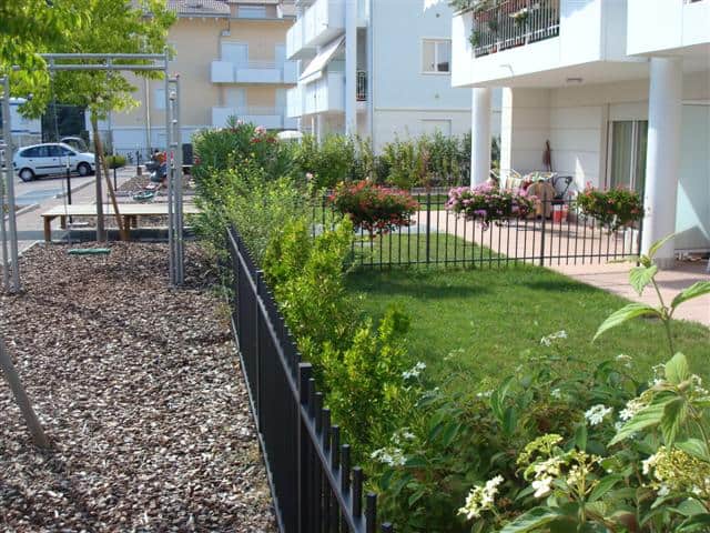 Giardino condominiale con area giochi e piante vicino a Residenza EOS.