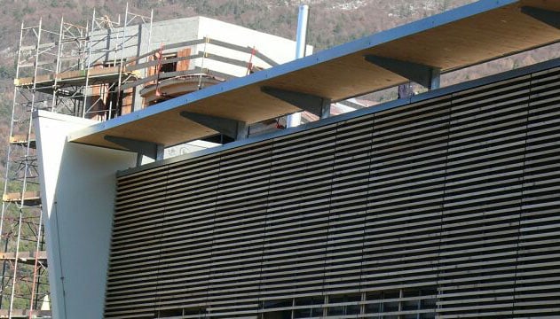 Edificio in costruzione con struttura moderna e rivestimento in pannelli di legno.