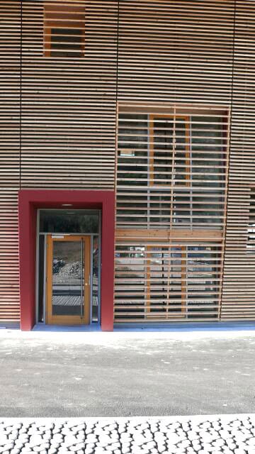Facciata moderna in legno con porta e finestra, design architettonico innovativo.