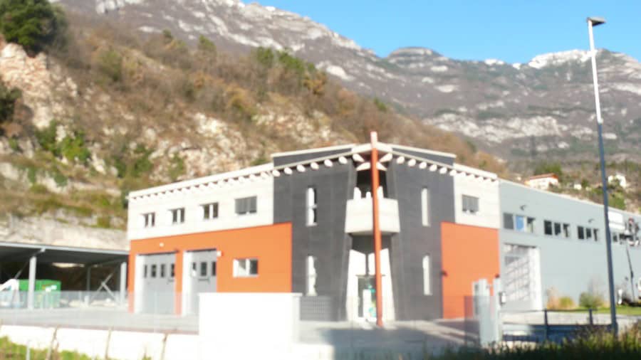Edificio industrial di Costruzioni Dallapè Srl con montagna sullo sfondo.