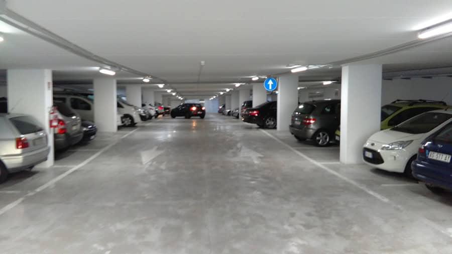 Garage coperto con auto parcheggiate, spazio ampio e illuminato.