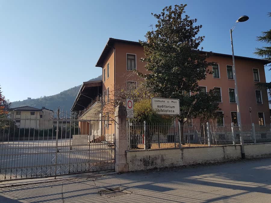 Edificio storico vicino alla biblioteca Mori con segnale stradale.