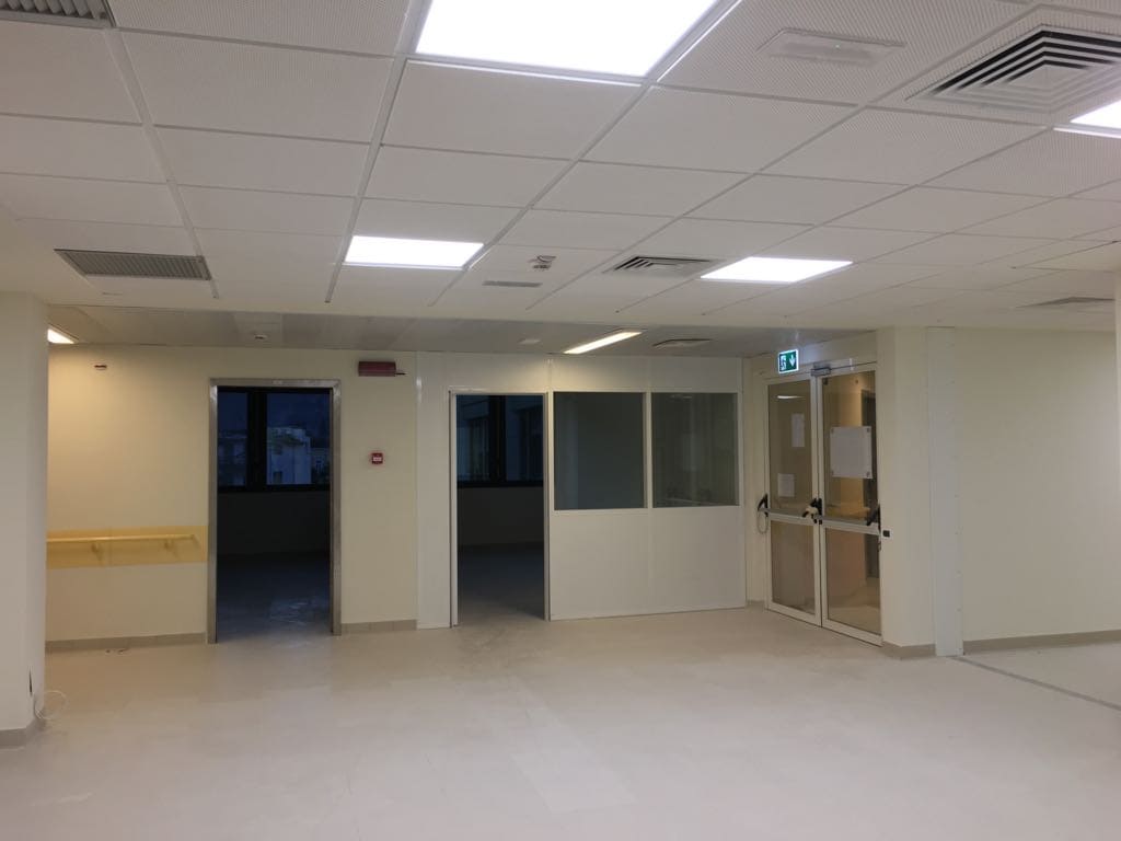 Interno nuovo dell'ospedale con pareti bianche e porte in vetro.