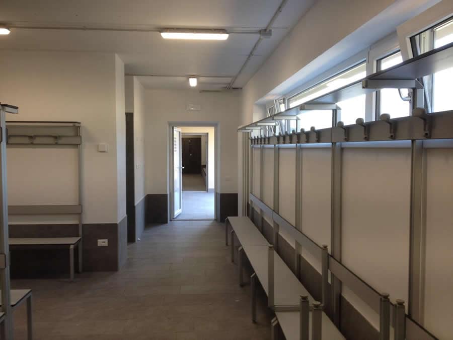 Interno di un edificio con scaffalature e finestre.