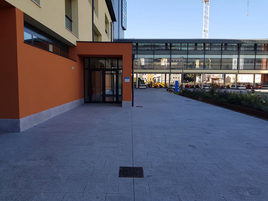 Esterno moderno di un edificio con facciata arancione e ingresso in vetro.
