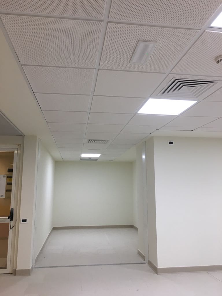 Interno ospedale con soffitto a pannelli e illuminazione LED.