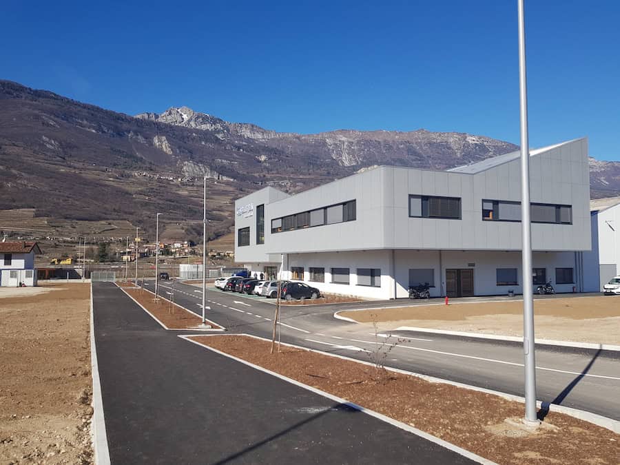 Capannone industriale moderno di Costruzioni Dallapè Srl in area montuosa.