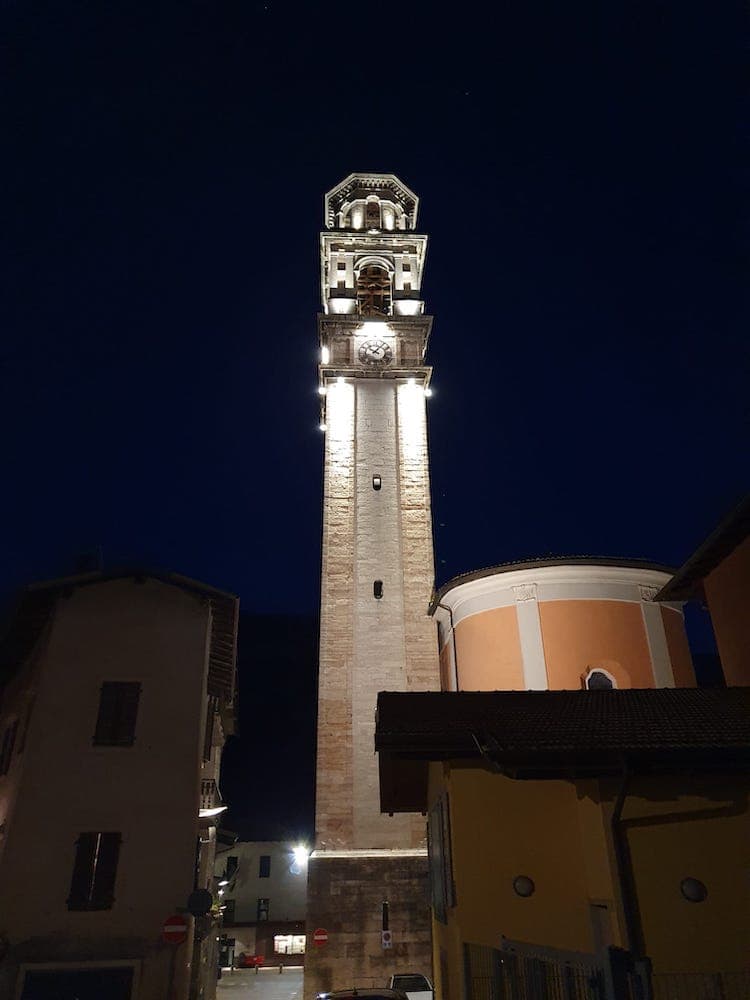 Torre campanaria della Chiesa di Aldeno illuminata di notte.