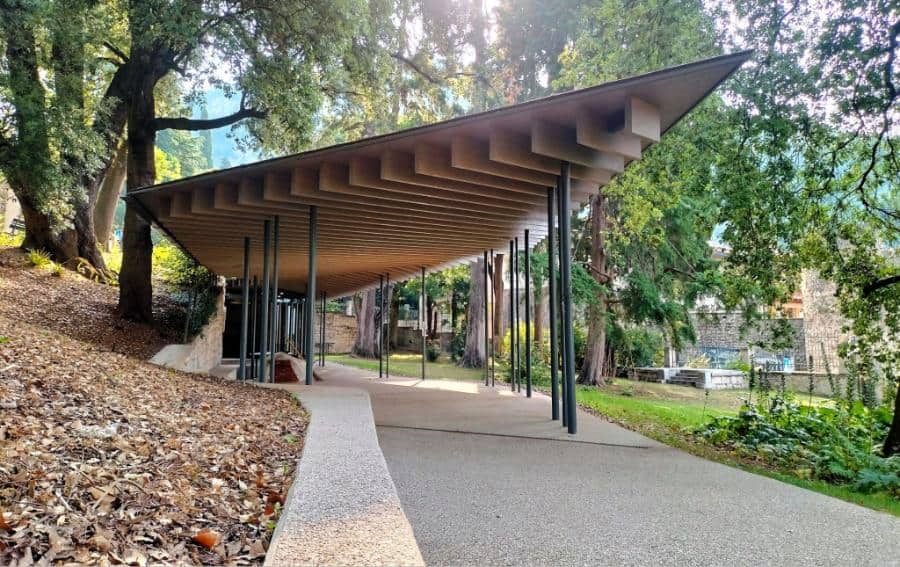 Struttura moderna nel Parco Arciducale Arco con copertura in legno e supporti metallici.