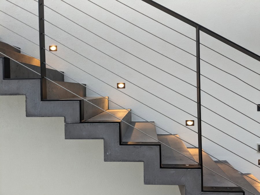 Scala moderna con illuminazione integrata e ringhiera in metallo.
