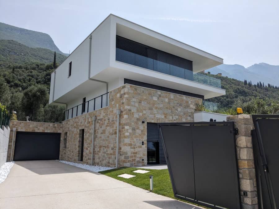 Villa moderna a Malcesine con facciata in pietra e grandi balconi.