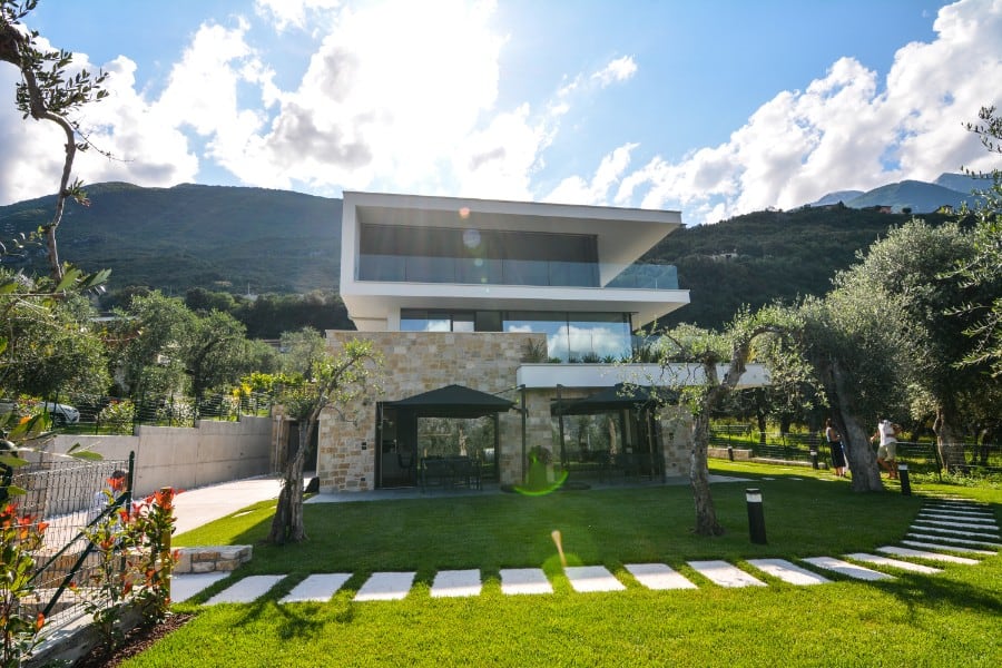 Villa moderna con vista sulle montagne e giardino ben curato.