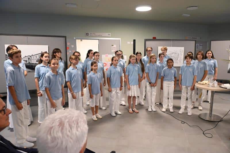 Gruppo di bambini in uniforme durante presentazione in aula.