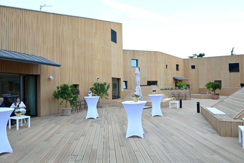 Terrazza moderna con tavoli e piante, costruzione Dallapè Srl a Riva del Garda.