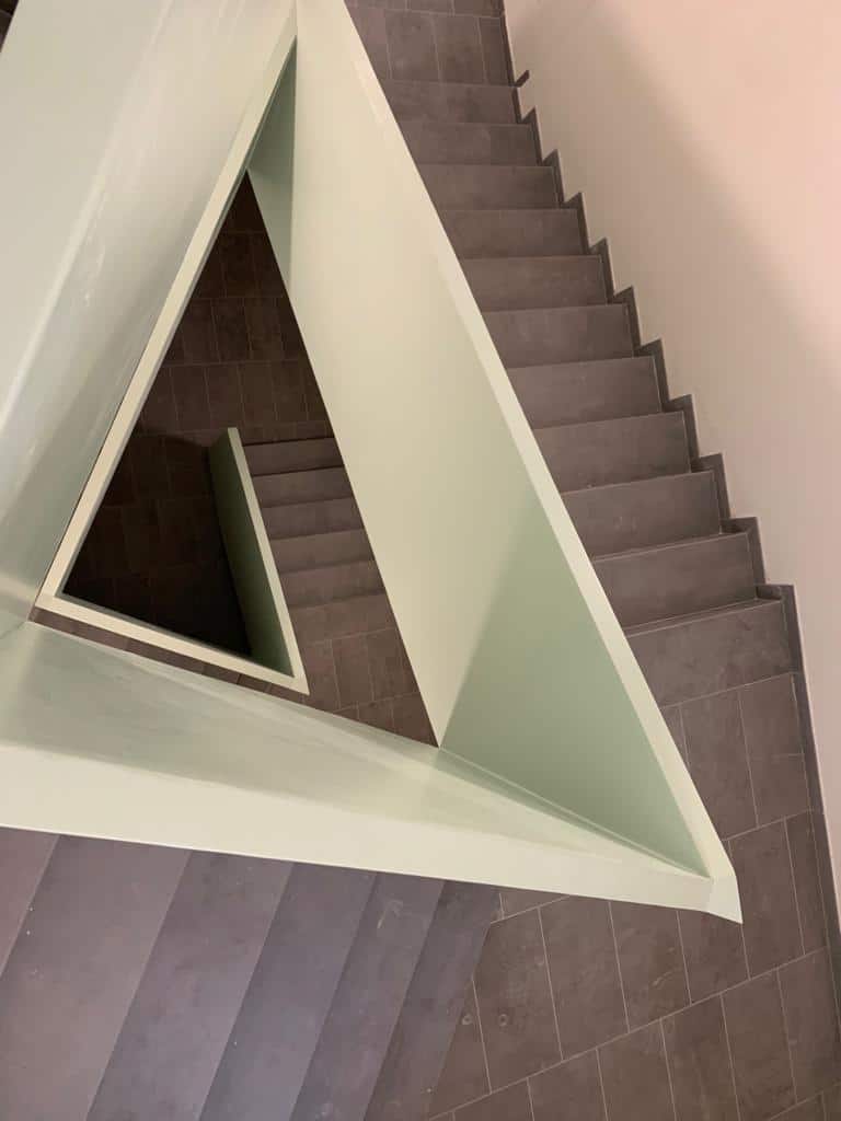 Scala moderna in pietra grigia con pareti bianche.