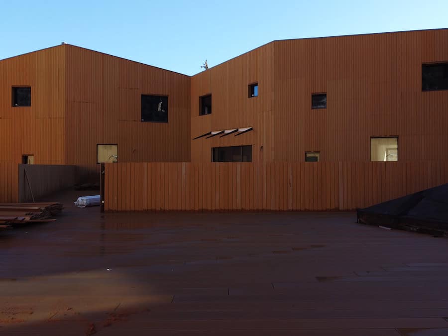 Edificio moderno in legno con finestre di varie dimensioni e forma.
