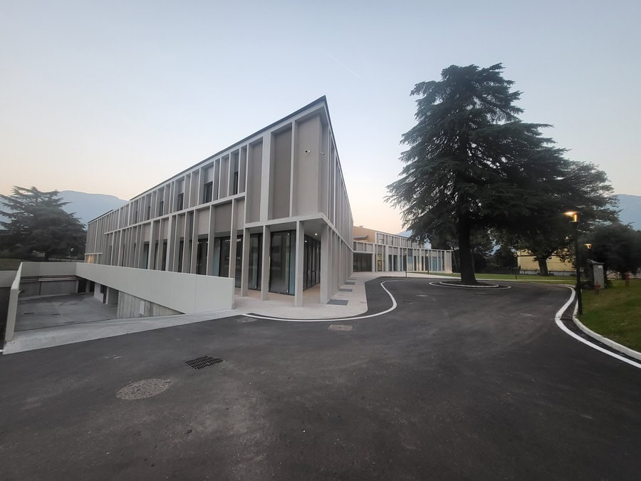 Edificio moderno con grandi finestre e alberi circostanti a Riva del Garda.