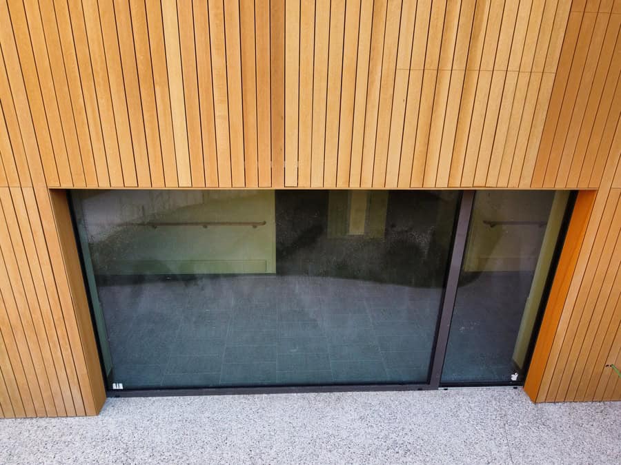 Finestra moderna con rivestimento in legno e vetro scorrevole.