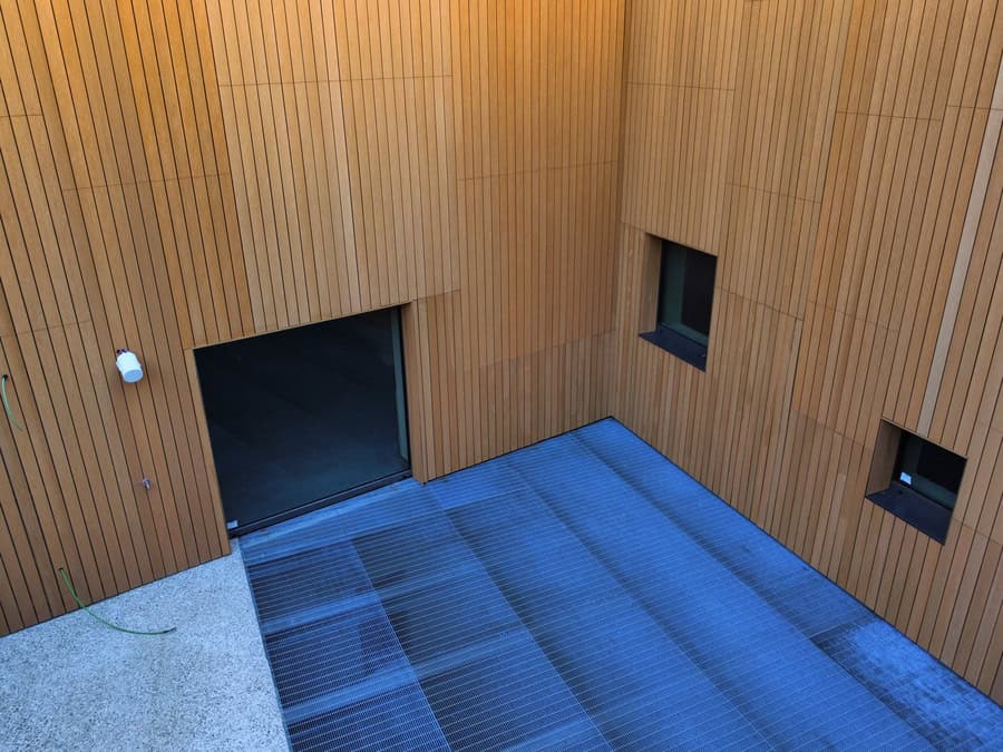 Facciata in legno con finestre e ingresso a raso.