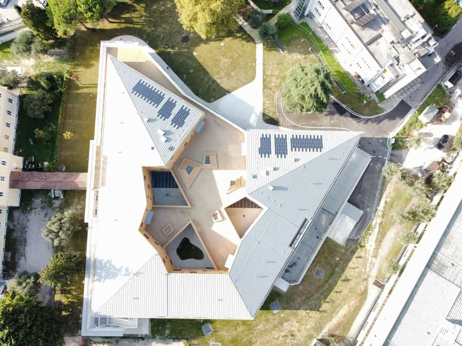 Costruzioni Dallapè Srl, edificio moderno con tetto a più pendenze e pannelli solari.