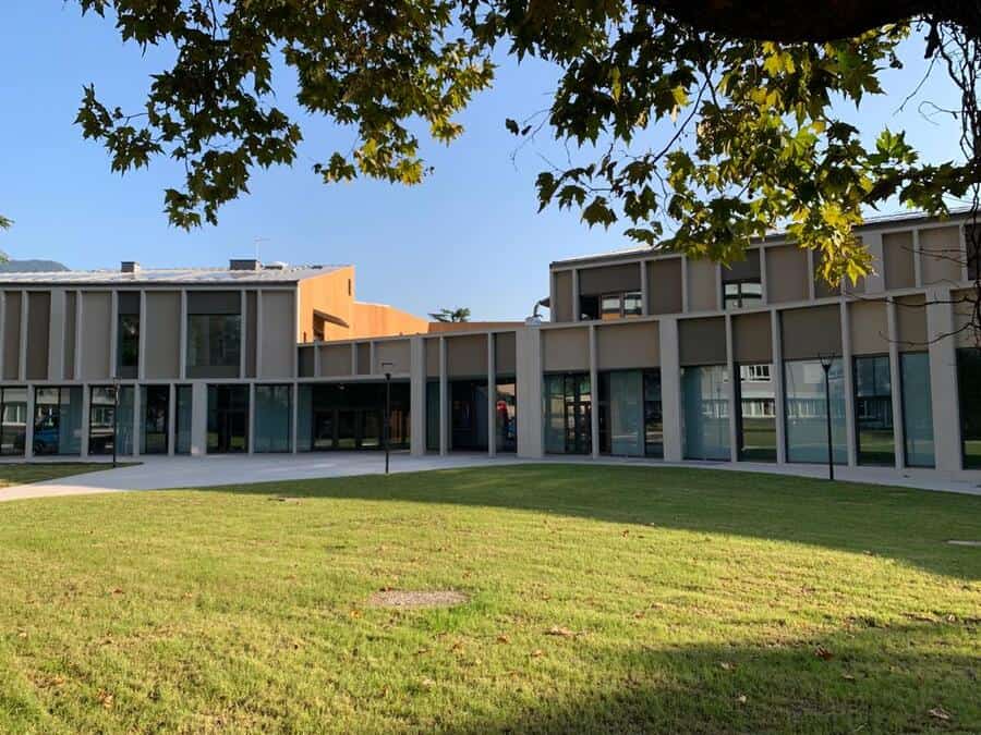 Costruzioni Dallapè Srl edificio moderno con ampio giardino verde.