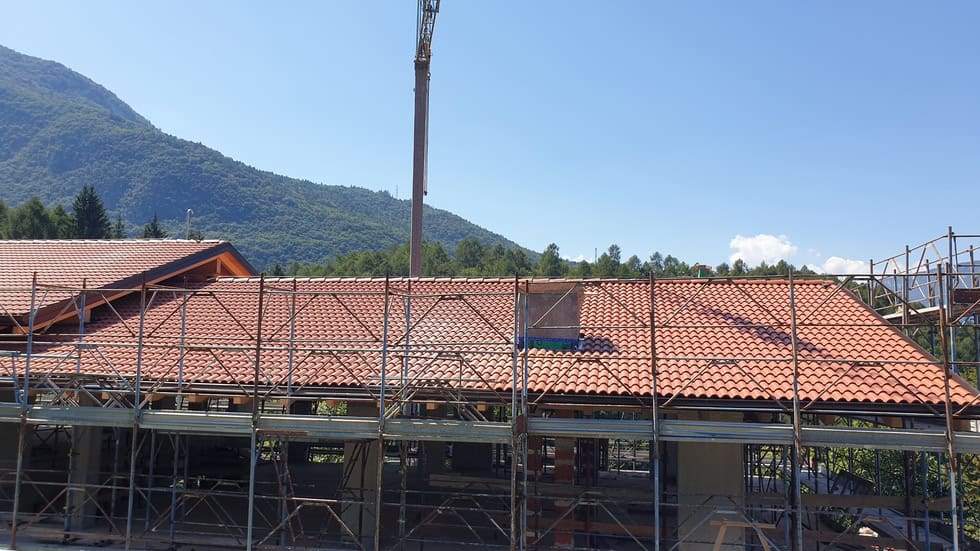 Tetto di una residenza privata in costruzione con copertura in tegole rosse.