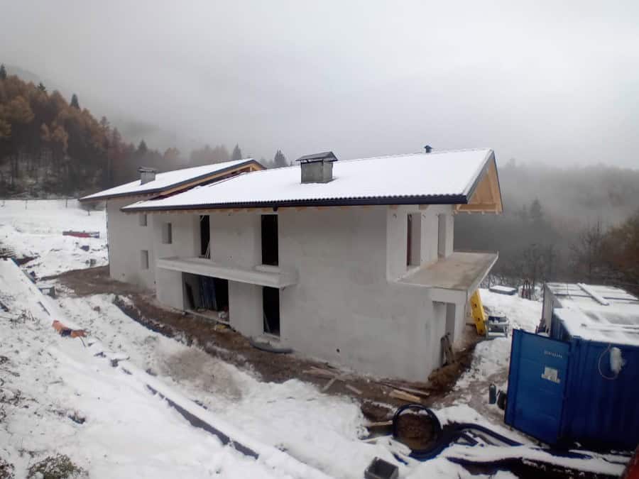 Costruzione di una nuova residenza privata a Drena in costruzione con neve e paesaggio montano.