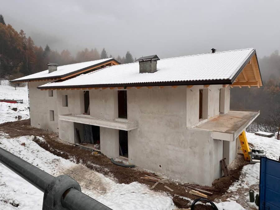 Costruzione di una nuova residenza privata a Drena con struttura in cemento e tetto in lamiera.