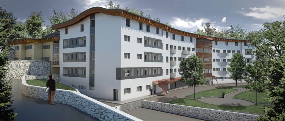 Edificio residenziale moderno in fase di costruzione con ampi spazi verdi.