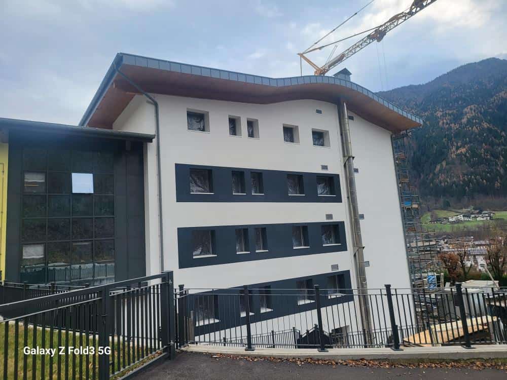 Edificio in costruzione con vista sulle montagne, cantiere in corso.
