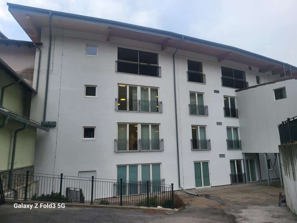 Edificio residenziale in fase di ristrutturazione con balconi e finestre moderne.