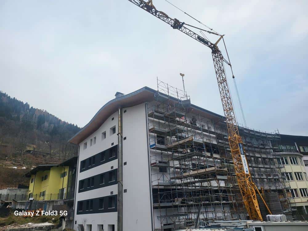 Costruzioni Dallapè Srl lavori di ristrutturazione edificio con gru e impalcature.
