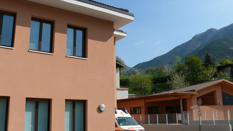Edificio residenziale a Bezzecca con montagne sullo sfondo.